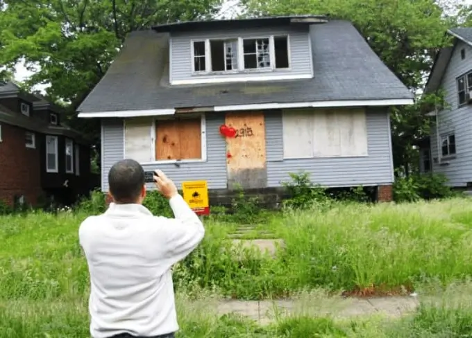 Real estate wholesaler taking picture vacant house